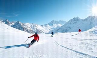Snow-covered ski slopes with skiers enjoying winter sports